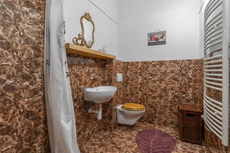I VILA REIM – Exkluzívna investičná príležitosť  - Kúpeľňa v chate s tapetou z mramorového dekoru, zrkadlom a umývadlom.