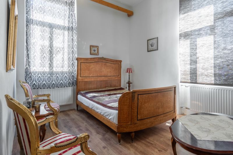 I VILA REIM – Exkluzívna investičná príležitosť  - Spálňa v chate s dreveným nábytkom, vzorované závesy a podlaha s dreveným dekorom.