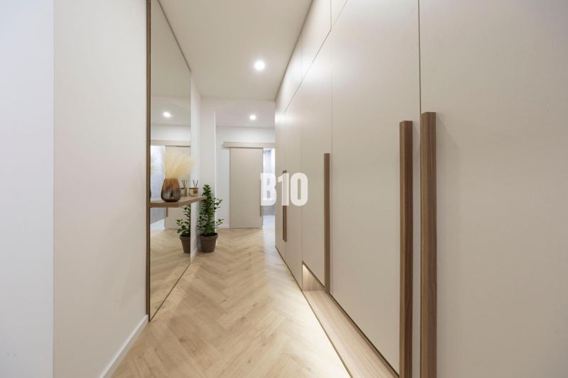 NOVO ZREKONŠTRUOVANÝ 4-IZBOVÝ BYT V TICHOM PROSTREDÍ - 78 m² - NOVÉ ME - Chodba s podlahou s dreveným dekorom v 4-izbovom byte, vstavané skrine a zrkadlo.