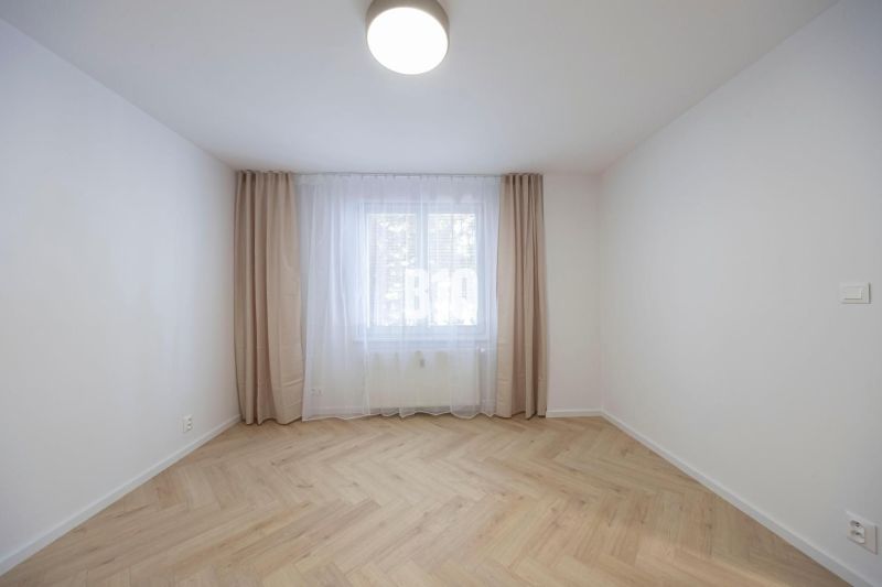 NOVO ZREKONŠTRUOVANÝ 4-IZBOVÝ BYT V TICHOM PROSTREDÍ - 78 m² - NOVÉ ME - Izba so závesmi a podlahou s dreveným dekorom v 4-izbovom byte.