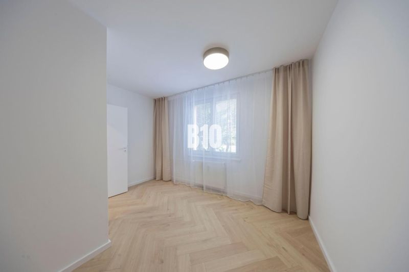 NOVO ZREKONŠTRUOVANÝ 4-IZBOVÝ BYT V TICHOM PROSTREDÍ - 78 m² - NOVÉ ME - Izba v 4-izbovom byte s podlahou s dreveným dekorom a veľkým oknom.