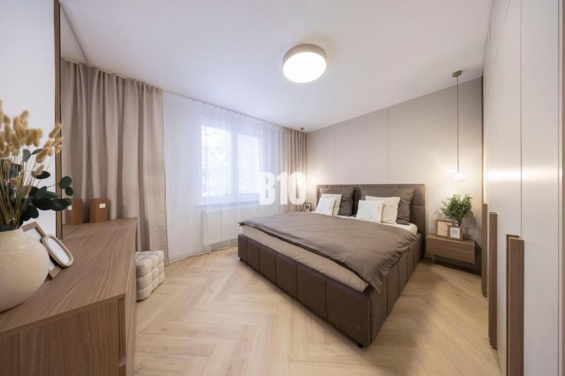 NOVO ZREKONŠTRUOVANÝ 4-IZBOVÝ BYT V TICHOM PROSTREDÍ - 78 m² - NOVÉ ME - Harmonická spálňa s podlahou s dreveným dekorom a zútulňujúcimi dekoráciami v 4-izbovom byte.