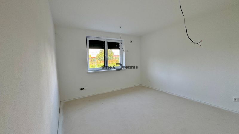 NA PREDAJ - Rodinný dom v JARKU, 4 izb. bungalov - Prázdna miestnosť s bielymi stenami a podlahou, okno s výhľadom do záhrady.