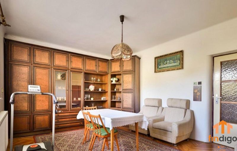PREDAJ - Rodinný dom s priestranným pozemkom 2266 m² - Veľký Kýr - Obývacia izba s podlahou s dreveným dekorom v rodinnom dome, útulné kreslá a skriňová zostava.