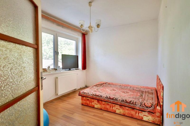 PREDAJ - Rodinný dom s priestranným pozemkom 2266 m² - Veľký Kýr - Na fotke je izba s podlahou s dreveným dekorom a posteľou v rodinnom dome.