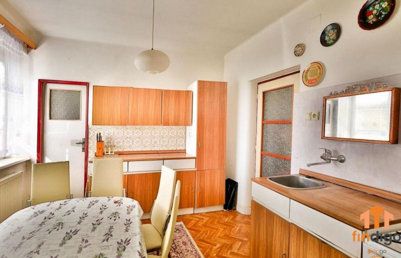 PREDAJ - Rodinný dom s priestranným pozemkom 2266 m² - Veľký Kýr - Kuchyňa v rodinnom dome s podlahou s dreveným dekorom a jedálenským stolom.