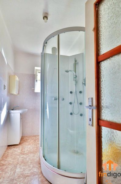 PREDAJ - Rodinný dom s priestranným pozemkom 2266 m² - Veľký Kýr - Kúpeľňa v rodinnom dome s rohovou sprchou a umývadlom, podlaha s dekorom dlaždíc.