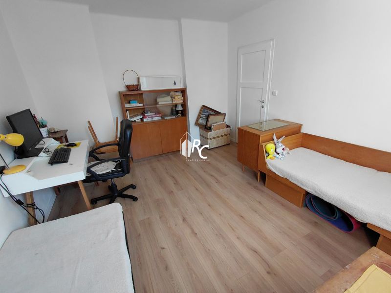 Na prenájom - Zariadený 3 izbový byt na Lipovci so záhradou - Pracovňa v 3-izbovom byte s písacím stolom, knihovňou a podlahou s dreveným dekorom.