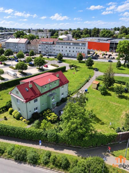 PREDAJ – 3-izbový byt v tehlovom dome so súkromným exteriérom - Nitra - Pohľad na dom s červenou strechou a zeleňou v Nitre na Štúrovej ulici.