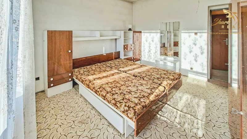 Slnečný dom  s možnosťou viacgeneračného bývania - Spálňa v rodinnom dome s posteľou a skriňou, ozdobená jemnými závesmi.