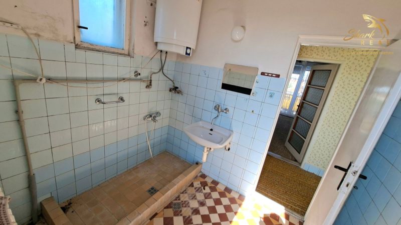 TOP PONUKA! 4 izbový rodinný dom - Kúpeľňa v rodinnom dome s modrými obkladačkami, umývadlom a plynovým kotlom.