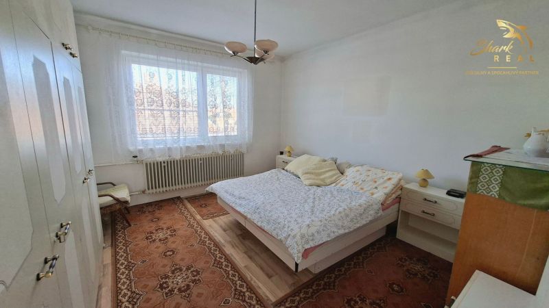 TOP PONUKA! 4 izbový rodinný dom - Spálňa v rodinnom dome s kobercom, posteľou a skriňou.