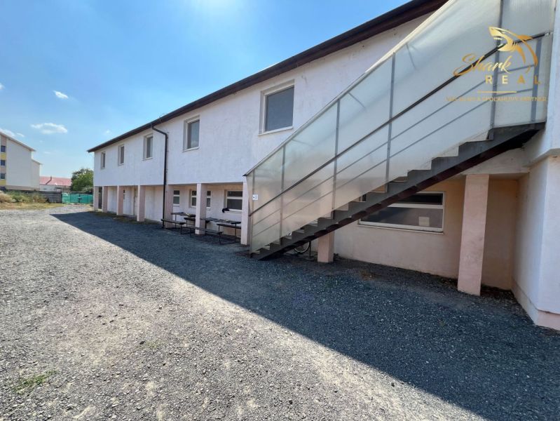 Obchodný priestor s ubytovacím zariadením - Exteriér gastro priestorov v Kozárovciach s vonkajším schodiskom a lavicami.