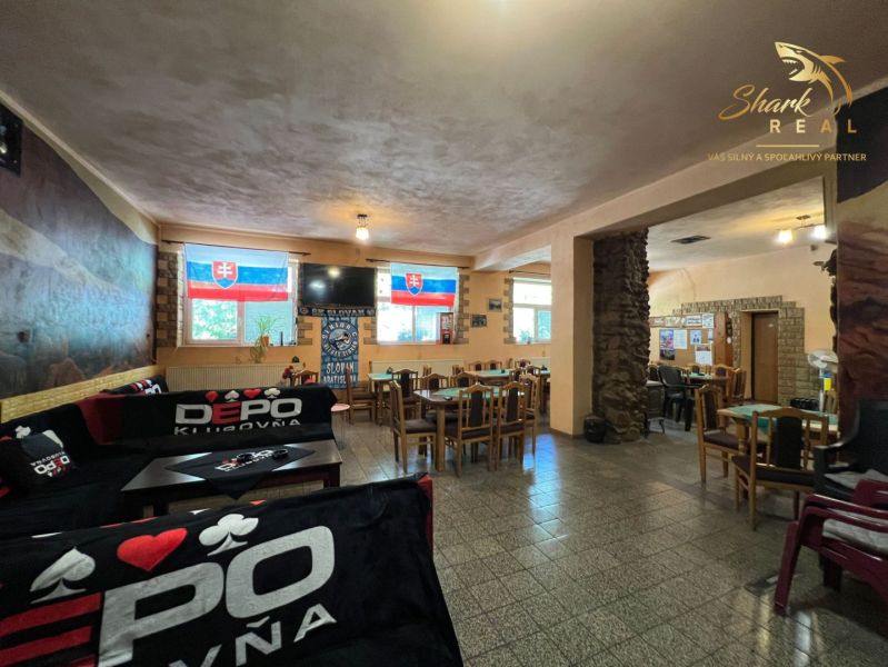 Obchodný priestor s ubytovacím zariadením - Interiér gastro priestorov s dreveným dekorom a slovenskými vlajkami na stenách.