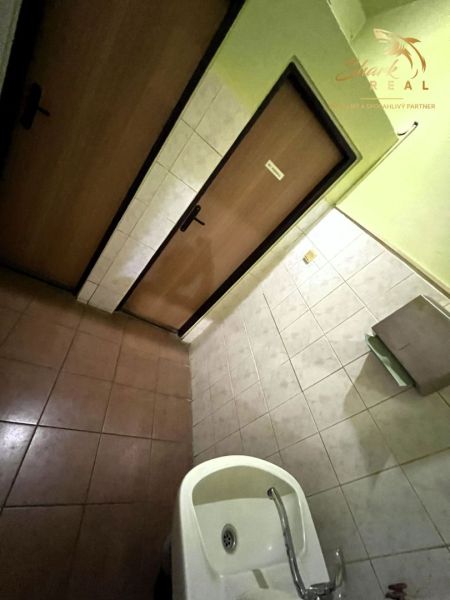 Obchodný priestor s ubytovacím zariadením - Interiér s keramickou dlažbou, umývadlom a dverami v gastro priestoroch.